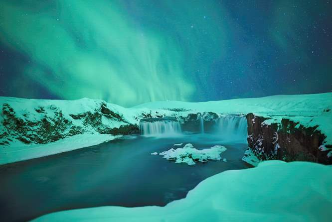 冰岛冬天在极光照亮的天空下众神瀑布的滔滔不绝