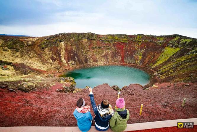 三人坐在Kerid火山口湖旁